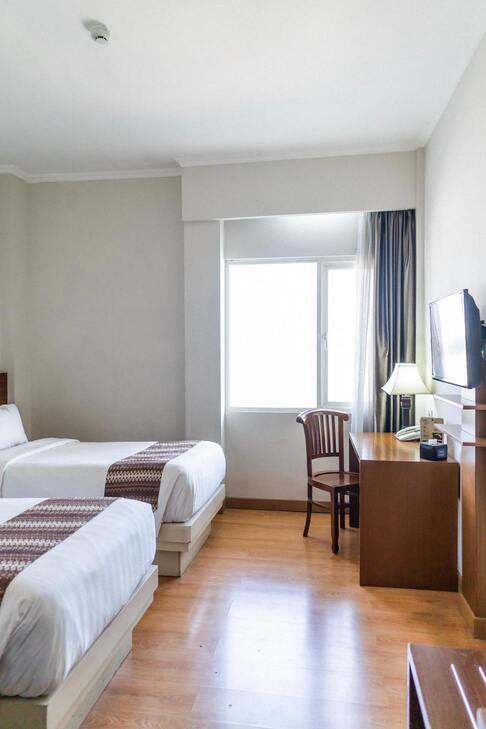 chambre avec deux lits, un bureau et une télé