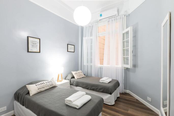 chambre avec deux lits et une fenêtre ouverte